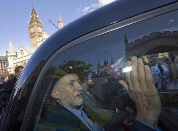 Newly elected leader of Britain's opposition Labour party, Jeremy Corbyn, passes the Houses of Parliament and Big Ben as he leaves in the back of a taxi after addressing a pro-refugee rally in central London on September 12, 2015. Anti-austerity leftwinger Jeremy Corbyn was elected leader of Britain's opposition Labour Party in a landslide victory that could divide the party and cause headaches for the government on foreign policy. Tens of thousands of Europeans rallied urging solidarity with the huge numbers of refugees entering the continent, as Hungary's populist premier said leaders were "in a dream world" about the dangers posed by the influx. AFP PHOTO / JUSTIN TALLIS / AFP PHOTO / JUSTIN TALLIS